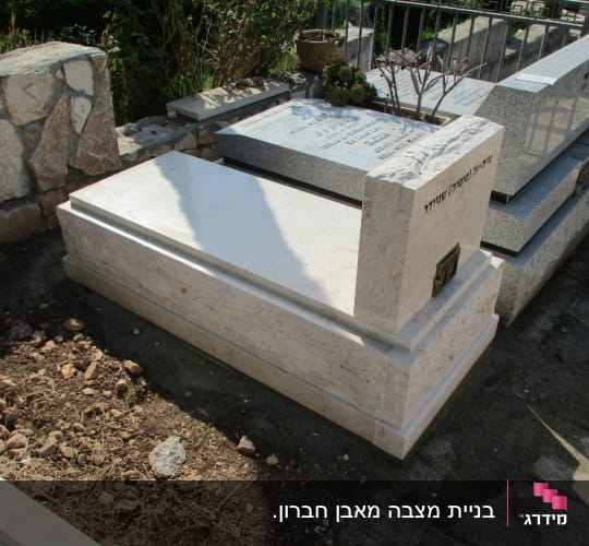 מצבת שיש בהירה בבית עלמין עם בית נר מובנה